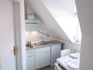 Een koelkast, een koffiezetapparaat/waterkoker, een waterkoker