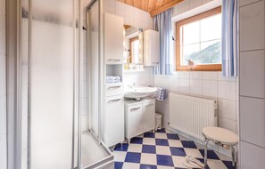 Bathroom features a sink, mirror, and vanity with drawers, as well as a radiator and window.
