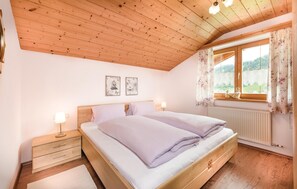 Relax in this serene bedroom with a double bed, large window, and beautiful views of the surrounding greenery.
