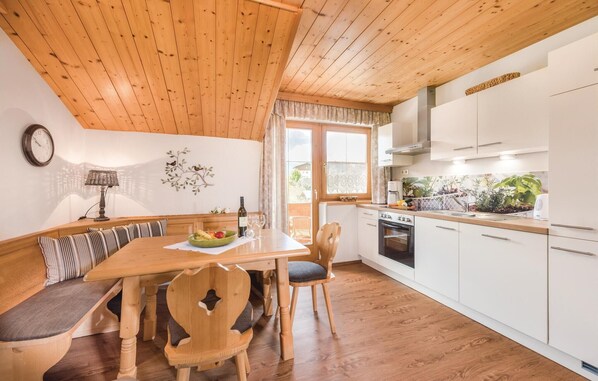 Enjoy meals in the dining area with a wooden table and chairs, and a comfortable bench.