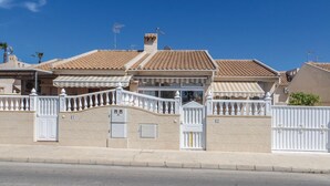 A residential building with a tiled roof, a gated entrance, and a small balcony. - Beach front home in Torrevieja with swimming pool (Torrevieja)