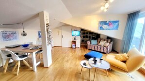 A modern living room with a sofa, a coffee table, and a TV. - (207) 2-room apartment - Appartementhaus Strandstr. 16 (Kühlungsborn)