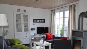 Ein modernes Wohnzimmer mit Kamin, Fernseher und einer Vitrine.