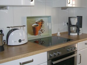A modern kitchen with a coffee maker, toaster, and a glass coffee display.
