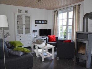 A modern living room with a fireplace, a television, and a cabinet with glass doors.