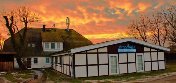 A building with a sign reading "strandhalle ahrenshop" and a traditional half-timbered facade. - Double room 05 (H) - guest house & beach hall (Ahrenshoop)