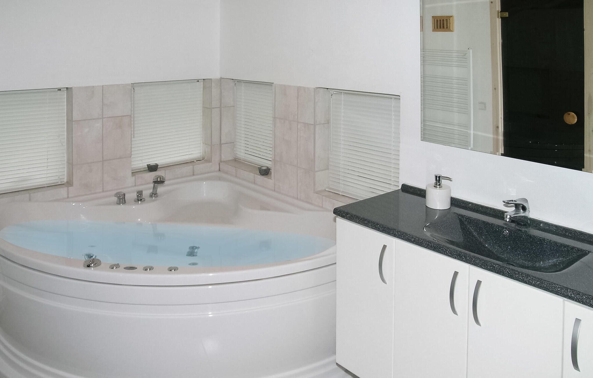 Une salle de bain avec une baignoire, un lavabo et un miroir.