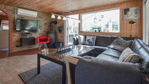 A cozy living room with a fireplace, a sofa, and a TV. - Gorgeous home in Spøttrup (Spøttrup)