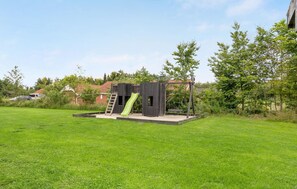 A playground with a slide and climbing structure in a grassy area. - Amazing home in Oksbøl with sauna (Oksbøl)