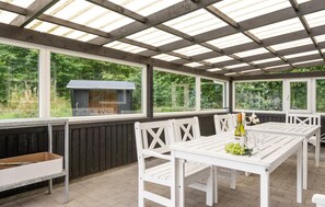 An outdoor patio with a grill, white wooden furniture, and large windows. - Amazing home in Oksbøl with sauna (Oksbøl)
