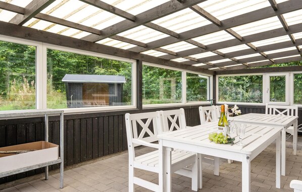 An outdoor patio with a grill, white wooden furniture, and large windows. - Amazing home in Oksbøl with sauna (Oksbøl)