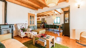 A cozy living room with a fireplace, wooden beams, and a dining area with a view. - Beautiful home in Prolozac Donji (Prolozac Donji)