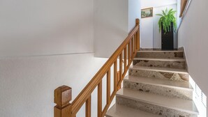 Un escalier avec des rampes en bois et des marches en pierre menant à un palier.
