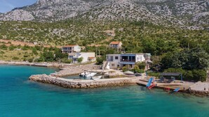 A coastal property with a stone pier, a small boat dock, and a mountainous backdrop. - 2 bedroom gorgeous apartment in Ribarica (Ribarica)