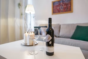Una botella de vino sobre una mesa con dos copas y una vela.