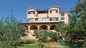 A multi-story residential building with a flat roof, satellite dish, and multiple balconies. - 2 bedroom pet friendly apartment in Zbandaj (Zbandaj)