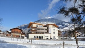 A multi-story building with a ski resort in the background.