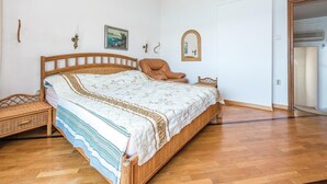Makuuhuoneessa on puinen sänky, tuoli, vaatekaappi ja ovi kylpyhuoneeseen.