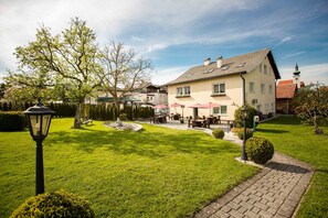Un hotel con césped cuidado, zona de estar al aire libre y un estilo arquitectónico tradicional.