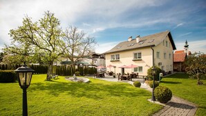 Ein Hotel mit gepflegtem Rasen, Sitzgelegenheiten im Freien und traditioneller Architektur.