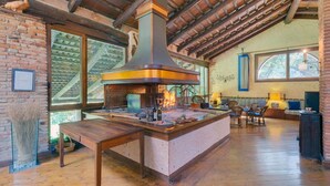 A rustic kitchen with a large stove, wooden beams, and a brick wall. - Gorgeous home in Barbarano Vicentino VI (Barbarano Vicentino VI)