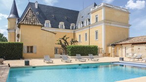 Un grande edificio con piscina, numerose finestre e una torre.