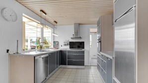 A modern kitchen with stainless steel appliances, a built-in oven, and a window providing natural light. - Gorgeous home in Hejls with WiFi (Hejls)