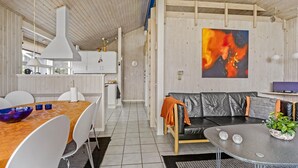 Eine moderne Küche mit weißen Schränken, einem Holzesstisch und einem schwarzen Ledersofa.