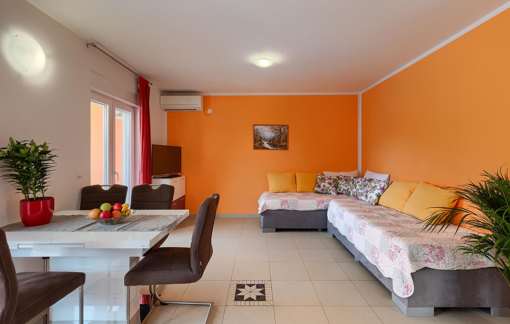 A compact living space with a dining area, a sofa, and a TV.