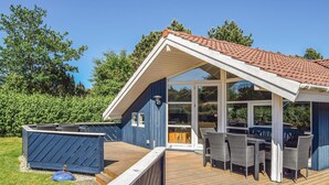 Un edificio blu con tetto spiovente e patio coperto con mobili da esterno.