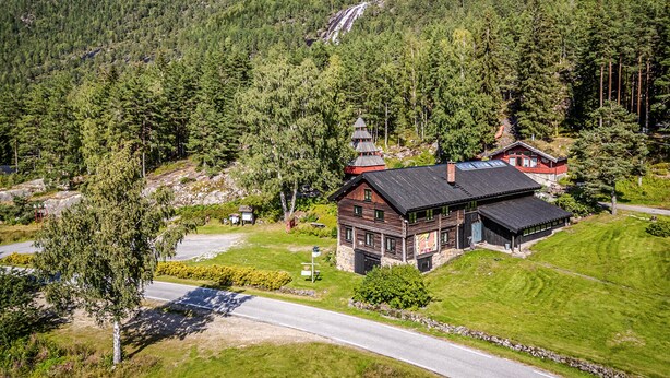 A wooden cabin with a steep roof, surrounded by dense forest and a mountain backdrop. - Pet friendly home in Dølemo with sauna (Dølemo)