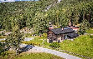 A wooden cabin with a steep roof, surrounded by dense forest and a mountain backdrop. - Pet friendly home in Dølemo with sauna (Dølemo)