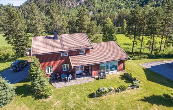 A two-story house with a red roof, a covered patio, and a car parked in the driveway. - Pet friendly home in Dølemo with sauna (Dølemo)