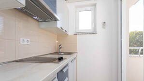 Een moderne keuken met een ingebouwde oven, een spoelbak en een raam boven de spoelbak.