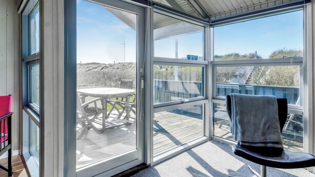 Een zonnige kamer met een schuifdeur die leidt naar een terras.