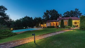 A villa with a swimming pool, a patio, and a well-maintained garden. - Amazing home in Belavici with sauna (Belavici)