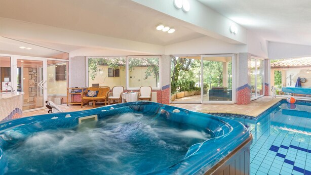 A spa area with a hot tub, a pool, and a seating area with a view of the outdoors. - Amazing home in Belavici with sauna (Belavici)