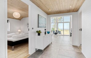 Een moderne slaapkamer met een bed, nachtkastje en uitzicht op de omgeving.