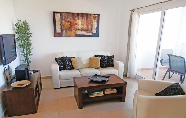 A living room with a white sofa, a coffee table, a television, and a plant. - 2 bedroom beautiful apartment in Sucina (Sucina)