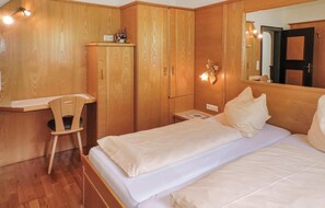 A bedroom with a bed, a desk, and a wardrobe. - sehr schoene Ferienwohnung (Schladming)