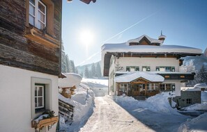 A snow-covered village with traditional wooden buildings, a clear sky, and a visible mountain in the background. - sehr schoene Ferienwohnung (Schladming)