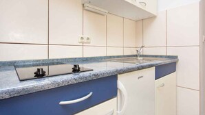 A kitchen with a granite countertop, white cabinets, and a built-in oven.