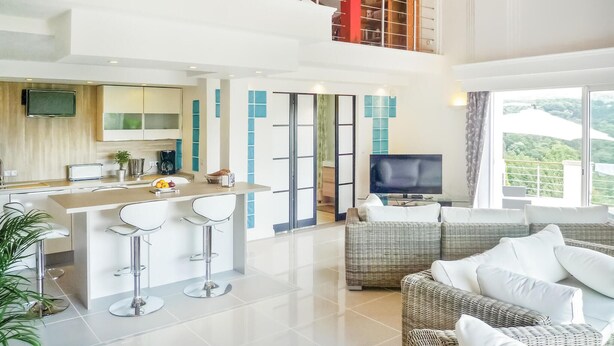 Eine moderne Wohnung mit Küche, Essbereich, Wohnzimmer und einem Balkon mit Blick.