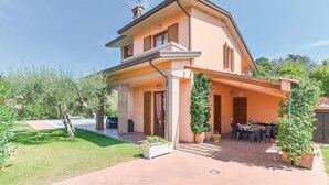 Une maison à deux étages avec un patio, une piscine et un jardin.