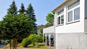 A residential house with a covered garage, a driveway, and a well-maintained lawn. - Vacation Rental in the Baltic Sea Resort of Göhren (01) - Vacation Rental with a Balcony (01) (Göhren)