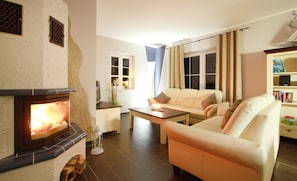 A living room with a fireplace, a sofa, a coffee table, and a bookshelf.