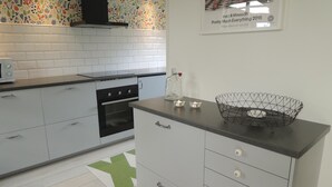 Une cuisine moderne avec des armoires blanches, une cuisinière noire et un pare-feu décoratif.