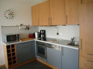 A kitchen with wooden cabinets, a microwave, a coffee maker, and a dishwasher.