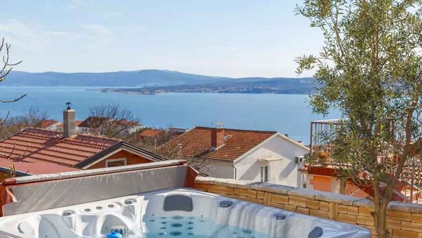 Ein Whirlpool mit Blick auf einen See und Berge.