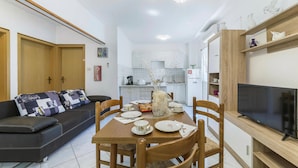 A compact living space with a dining area, a sofa, a TV, and a kitchenette. - Cozy home in Labin with kitchen (Labin)